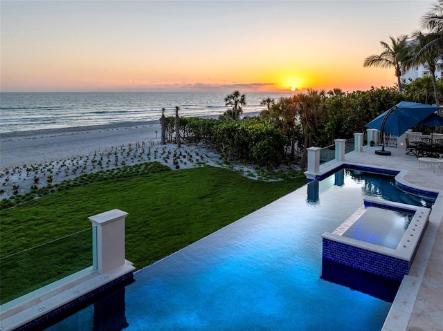845 Longboat Club Rd, Longboat Key, FL 34228 - pool at dusk with view of water and beach, an infinity pool, a patio area, an in-ground hot tub, and a lawn