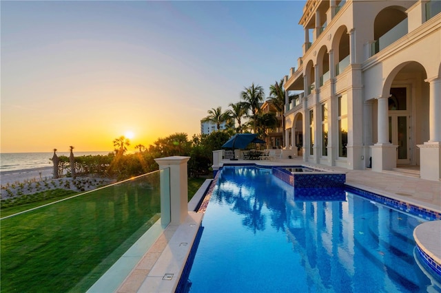 845 Longboat Club Rd, Longboat Key, FL 34228 - pool at dusk featuring a patio, a pool with connected hot tub, and a water view