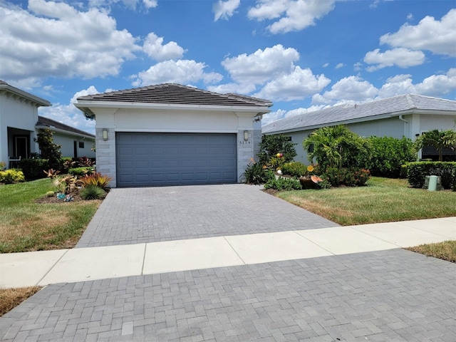 5219 Barnett Cir, Bradenton, FL 34211 - ranch-style home featuring a front lawn, a tiled roof, decorative driveway, a garage, and stucco siding
