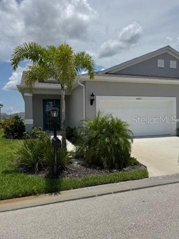 24827 Buckingham Way, Port Charlotte, FL 33980 - view of front of house featuring a garage, stucco siding, and concrete driveway