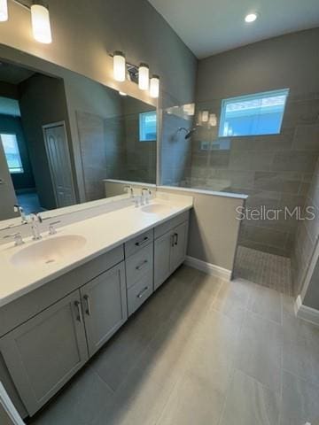24827 Buckingham Way, Port Charlotte, FL 33980 - bathroom featuring double vanity, walk in shower, plenty of natural light, baseboards, and recessed lighting