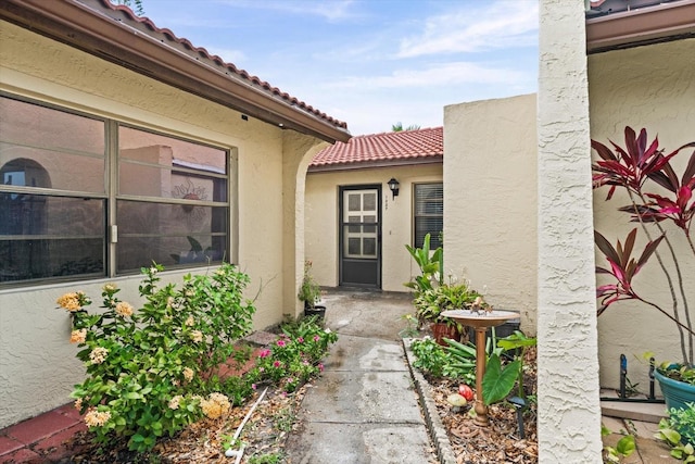 1227 56th St W Unit 1227, Bradenton, FL 34209 - view of exterior entry with a tile roof and stucco siding