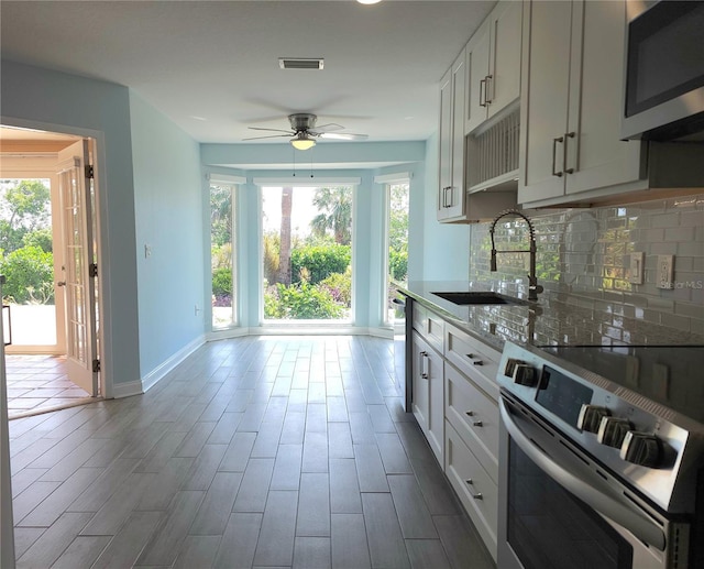 5207 86th Street Ct W, Bradenton, FL 34210 - kitchen with appliances with stainless steel finishes, a sink, baseboards, ceiling fan, and backsplash