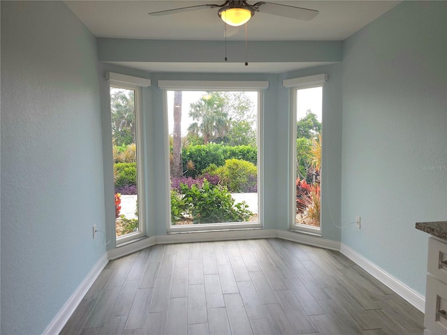 5207 86th Street Ct W, Bradenton, FL 34210 - empty room with a ceiling fan, healthy amount of natural light, baseboards, wood finished floors, and a textured wall