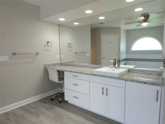 5207 86th Street Ct W, Bradenton, FL 34210 - bathroom with ceiling fan, a bath, vanity, wood finished floors, and recessed lighting