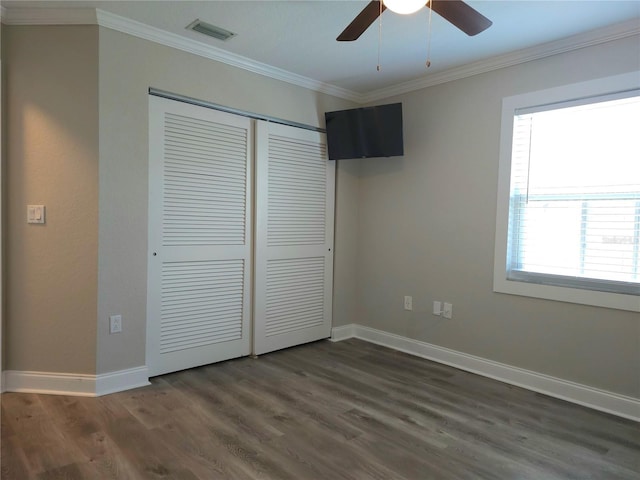 5207 86th Street Ct W, Bradenton, FL 34210 - unfurnished bedroom featuring a closet, dark wood-style flooring, crown molding, baseboards, and a ceiling fan