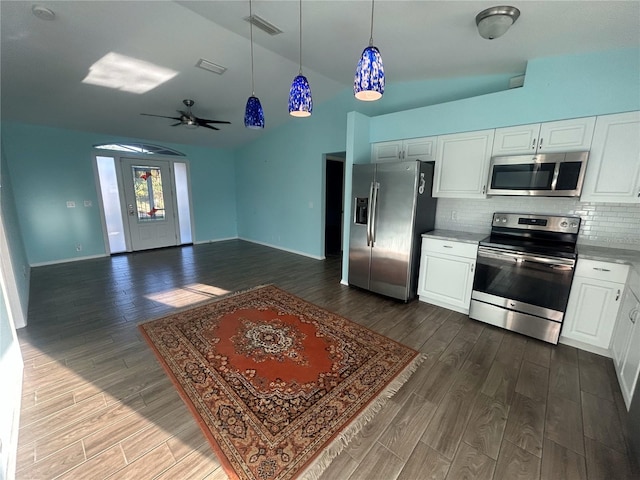 3339 Duar Ter, North Port, FL 34291 - kitchen with stainless steel appliances, vaulted ceiling, dark wood-style flooring, tasteful backsplash, and white cabinetry