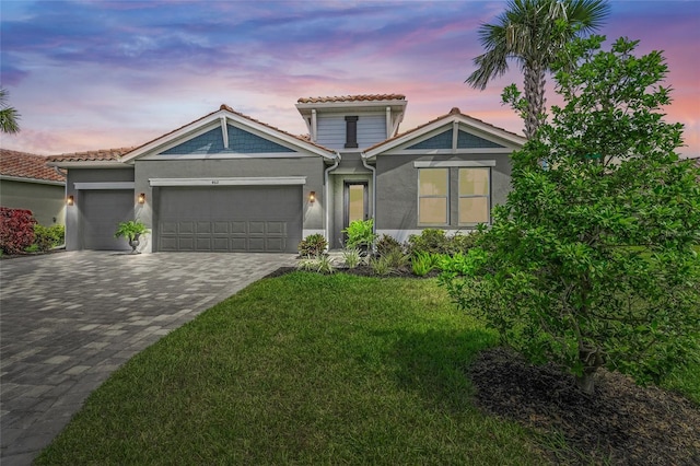 460 Daylily Blvd, Nokomis, FL 34275 - view of front of house featuring stucco siding, a garage, decorative driveway, a tile roof, and a lawn