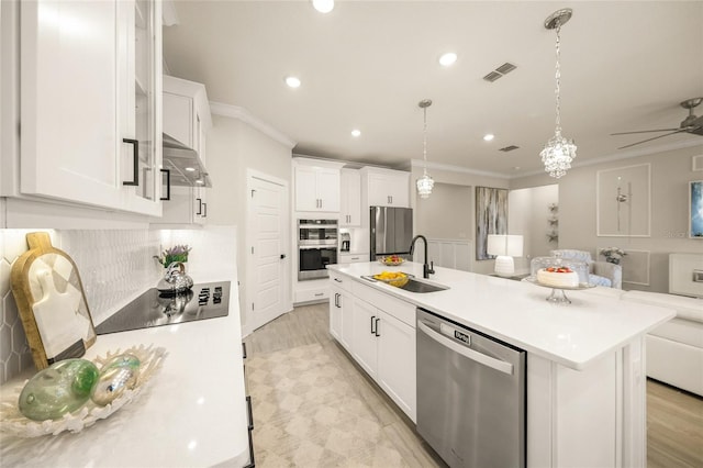 460 Daylily Blvd, Nokomis, FL 34275 - kitchen with stainless steel appliances, a sink, crown molding, light countertops, and white cabinetry