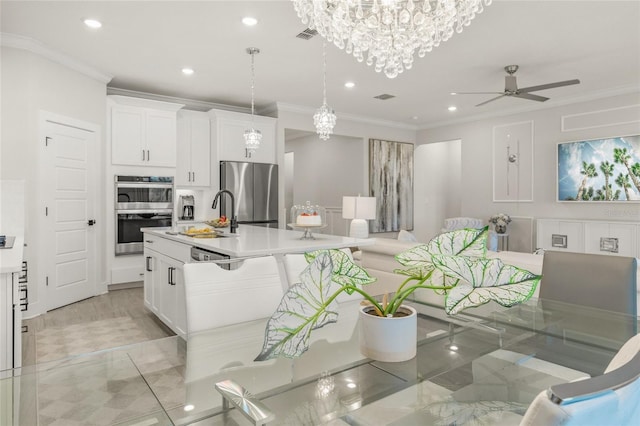 460 Daylily Blvd, Nokomis, FL 34275 - kitchen featuring appliances with stainless steel finishes, a sink, a ceiling fan, crown molding, and a chandelier