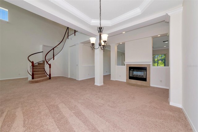 4307 70th Ave E, Ellenton, FL 34222 - unfurnished living room with carpet floors, stairway, crown molding, a tray ceiling, and a fireplace