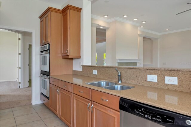 4307 70th Ave E, Ellenton, FL 34222 - kitchen featuring appliances with stainless steel finishes, a sink, brown cabinetry, light stone countertops, and light tile patterned floors