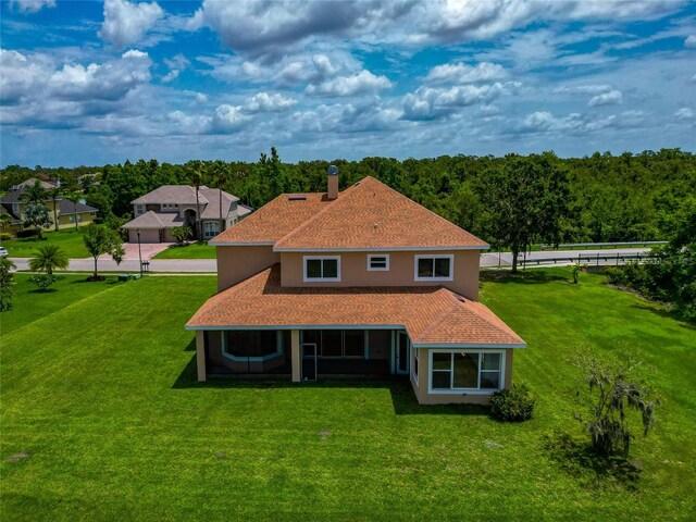 4307 70th Ave E, Ellenton, FL 34222 - rear view of property with a yard, stucco siding, a sunroom, and a chimney
