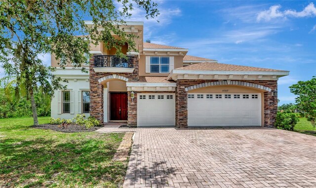 4307 70th Ave E, Ellenton, FL 34222 - view of front of home featuring a balcony, decorative driveway, stone siding, and stucco siding