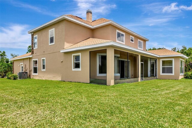 4307 70th Ave E, Ellenton, FL 34222 - back of house with stucco siding, central AC, a yard, a chimney, and a sunroom