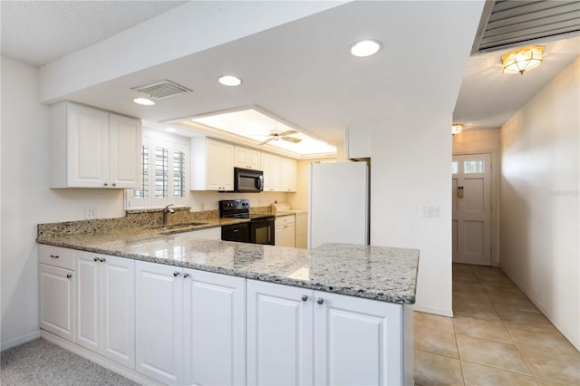 9412 Concord Cir, Bradenton, FL 34210 - kitchen featuring black appliances, a sink, light stone counters, plenty of natural light, and recessed lighting