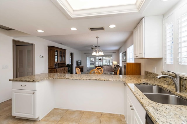 9412 Concord Cir, Bradenton, FL 34210 - kitchen featuring a sink, recessed lighting, white cabinets, a chandelier, and light stone counters