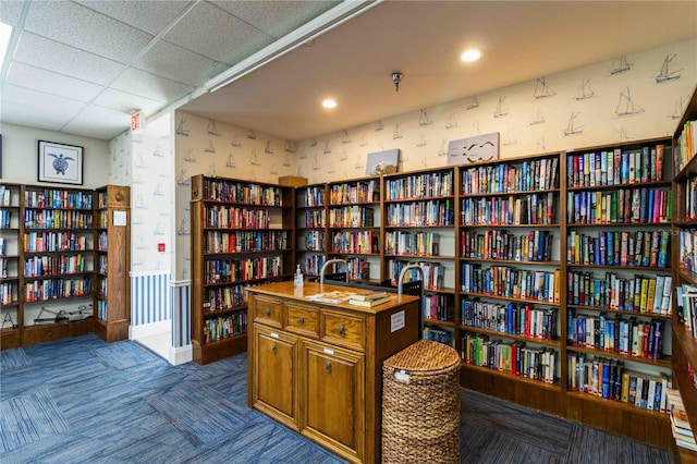 9412 Concord Cir, Bradenton, FL 34210 - living area featuring bookshelves, wallpapered walls, dark colored carpet, and recessed lighting