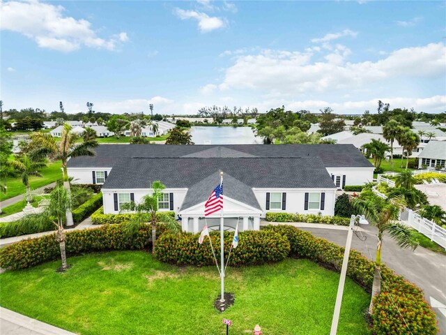 9412 Concord Cir, Bradenton, FL 34210 - view of front of home featuring a front lawn, a shingled roof, and a water view