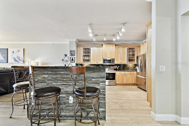 2825 Terra Ceia Bay Blvd Unit 1804, Palmetto, FL 34221 - kitchen with appliances with stainless steel finishes, light brown cabinets, glass insert cabinets, dark countertops, and a breakfast bar area
