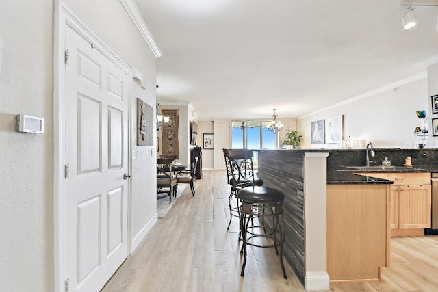 2825 Terra Ceia Bay Blvd Unit 1804, Palmetto, FL 34221 - kitchen with a breakfast bar area, dark countertops, light wood-type flooring, a chandelier, and ornamental molding