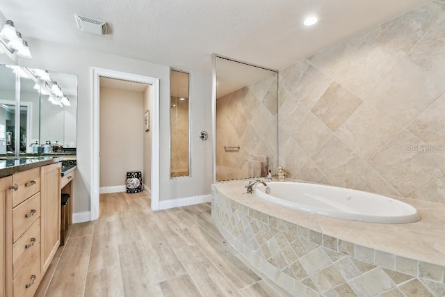 2825 Terra Ceia Bay Blvd Unit 1804, Palmetto, FL 34221 - full bath with vanity, a garden tub, wood finished floors, and recessed lighting
