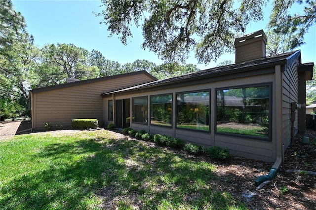 4555 Chandlers Forde Unit 47, Sarasota, FL 34235 - back of house with a chimney, a sunroom, and a yard