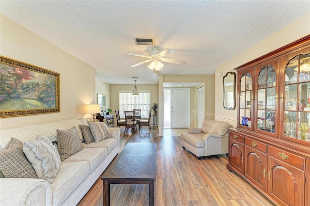 6804 19th Ave W, Bradenton, FL 34209 - living room with light wood-style floors, ceiling fan, and a textured ceiling