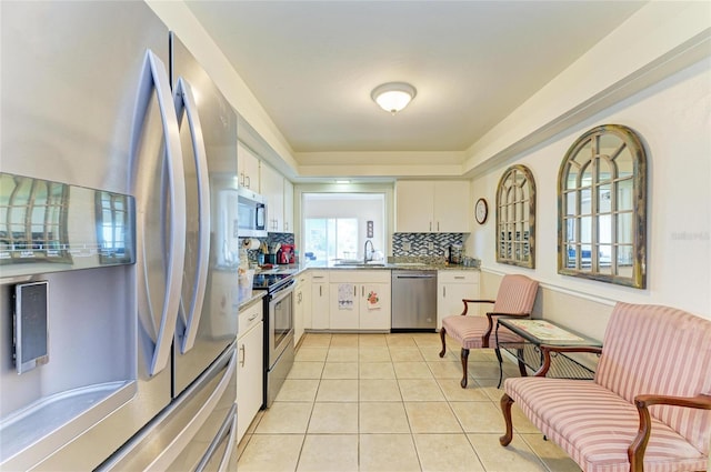 6804 19th Ave W, Bradenton, FL 34209 - kitchen featuring stainless steel appliances, backsplash, light tile patterned floors, and white cabinets