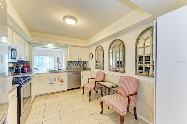 6804 19th Ave W, Bradenton, FL 34209 - kitchen with stainless steel appliances, backsplash, light tile patterned floors, and a raised ceiling