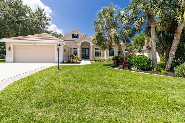 866 Oak Briar Ln, Osprey, FL 34229 - mediterranean / spanish house featuring stucco siding, a garage, concrete driveway, a front yard, and a tile roof