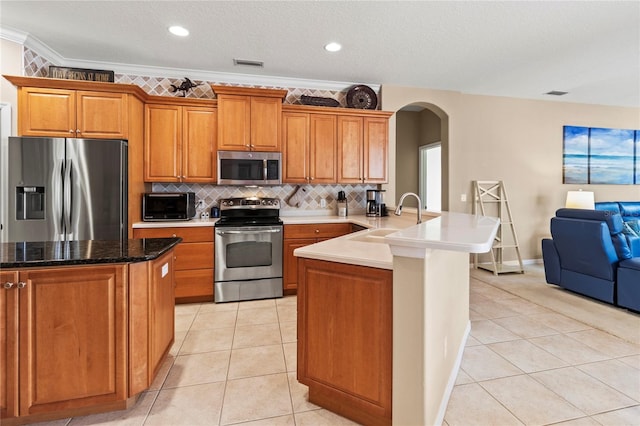 866 Oak Briar Ln, Osprey, FL 34229 - kitchen with appliances with stainless steel finishes, a sink, arched walkways, a peninsula, and backsplash