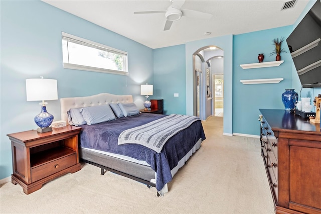 866 Oak Briar Ln, Osprey, FL 34229 - bedroom with arched walkways, light colored carpet, a ceiling fan, baseboards, and connected bathroom