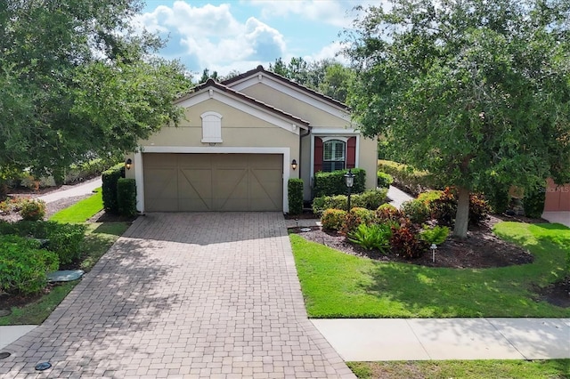 5117 Serata Dr, Bradenton, FL 34211 - view of front facade featuring a garage, decorative driveway, stucco siding, and a front yard