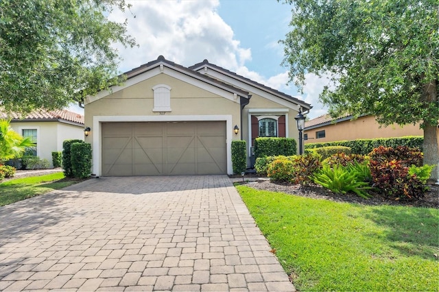 5117 Serata Dr, Bradenton, FL 34211 - ranch-style house featuring decorative driveway, a garage, stucco siding, and a front yard