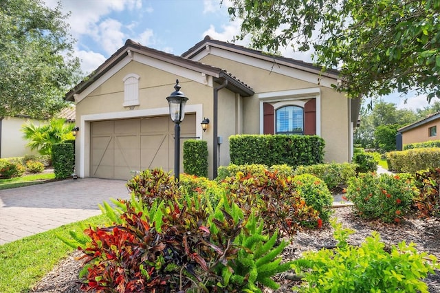 5117 Serata Dr, Bradenton, FL 34211 - view of front of house featuring an attached garage, stucco siding, and decorative driveway