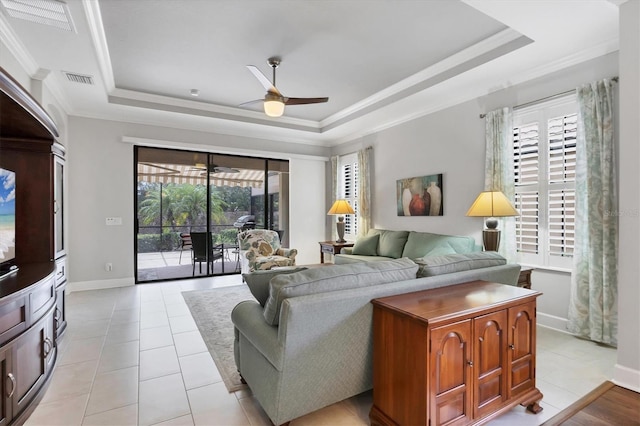 5117 Serata Dr, Bradenton, FL 34211 - living room featuring a tray ceiling, ceiling fan, crown molding, baseboards, and light tile patterned floors