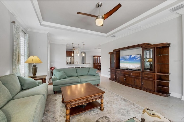 5117 Serata Dr, Bradenton, FL 34211 - living area featuring a raised ceiling, a ceiling fan, baseboards, crown molding, and light tile patterned floors