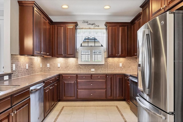 5117 Serata Dr, Bradenton, FL 34211 - kitchen featuring stainless steel appliances, inlaid floor details, decorative backsplash, light tile patterned floors, and crown molding