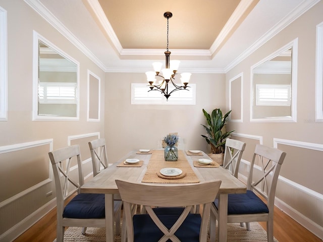 4949 Savona Run, Bradenton, FL 34211 - dining area with a chandelier, a tray ceiling, crown molding, and wood finished floors