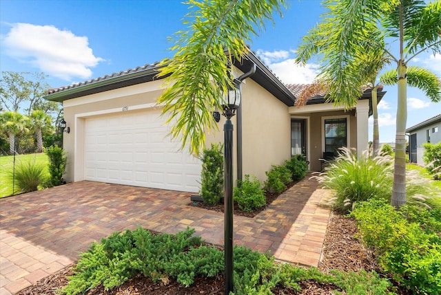 6791 Alstead Cir, Bradenton, FL 34202 - view of front of house with stucco siding, a garage, and decorative driveway