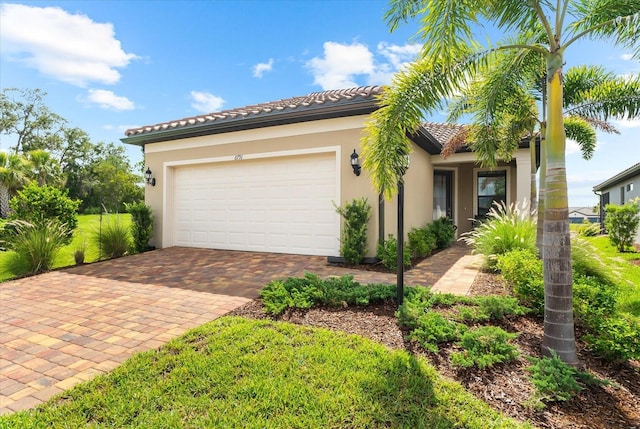 6791 Alstead Cir, Bradenton, FL 34202 - mediterranean / spanish house featuring decorative driveway, stucco siding, a garage, and a tiled roof