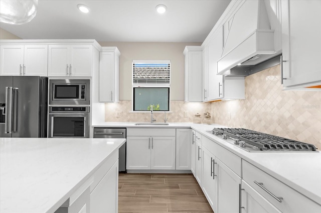 6791 Alstead Cir, Bradenton, FL 34202 - kitchen featuring premium range hood, appliances with stainless steel finishes, light countertops, white cabinetry, and backsplash