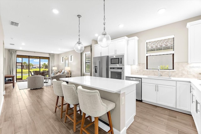 6791 Alstead Cir, Bradenton, FL 34202 - kitchen featuring stainless steel appliances, a center island, light wood finished floors, decorative backsplash, and recessed lighting