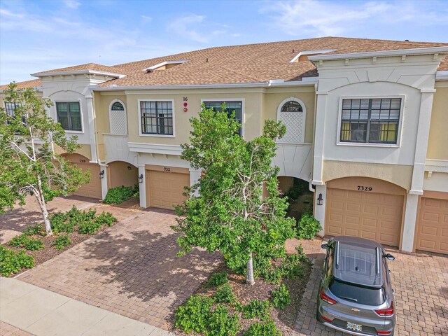 7325 Skybird Rd Unit 399, Bradenton, FL 34209 - view of front of house with a garage, stucco siding, driveway, and a shingled roof