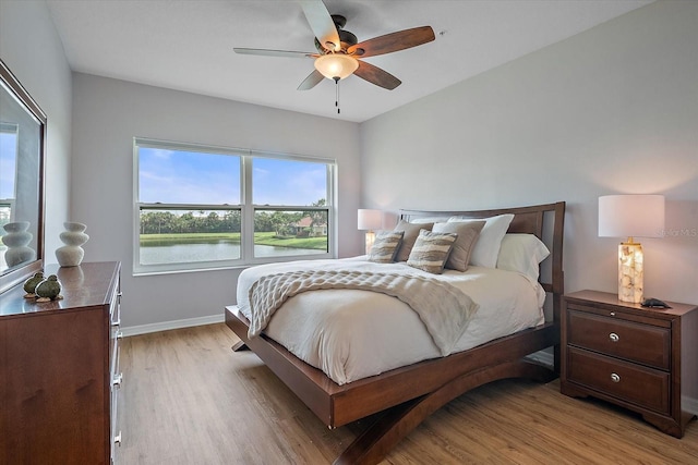 7325 Skybird Rd Unit 399, Bradenton, FL 34209 - bedroom with light wood-type flooring, baseboards, a ceiling fan, and a water view