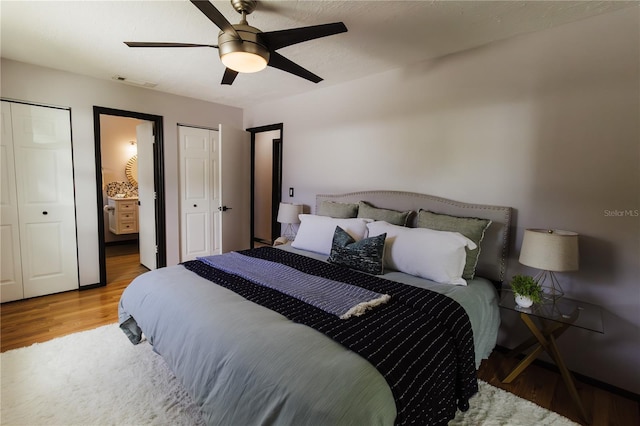 4945 Camphor Ave, Sarasota, FL 34231 - bedroom with wood finished floors, ceiling fan, multiple closets, and ensuite bathroom