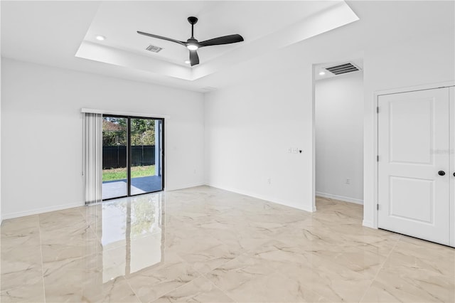 920 Barton St E, Lehigh Acres, FL 33974 - spare room with a tray ceiling, light marble finish flooring, a ceiling fan, baseboards, and recessed lighting