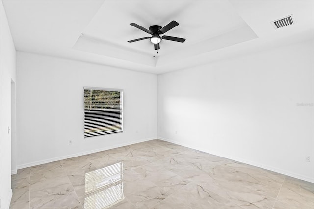 920 Barton St E, Lehigh Acres, FL 33974 - spare room with a raised ceiling, marble finish floors, a ceiling fan, and baseboards