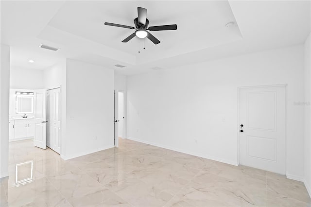 920 Barton St E, Lehigh Acres, FL 33974 - spare room with a tray ceiling, ceiling fan, light marble finish floors, and baseboards
